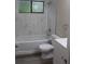Stylish bathroom with marble-look tiled walls, tub, shower, and modern fixtures at 1550 Maxwell Ln, Deltona, FL 32738