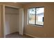 Bedroom with a window view to fenced yard, featuring bi-fold closet doors and neutral carpet at 1550 Maxwell Ln, Deltona, FL 32738
