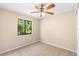Bedroom showcasing window with lush greenery view and neutral carpet at 1550 Maxwell Ln, Deltona, FL 32738