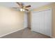 Cozy bedroom with neutral color palette, ceiling fan, and double door closet at 1550 Maxwell Ln, Deltona, FL 32738