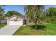Charming front exterior view of a one-story home, lush lawn, large driveway, and a two-car garage at 1550 Maxwell Ln, Deltona, FL 32738