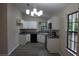 Bright kitchen features white cabinets, granite countertops, and stainless steel appliances at 1550 Maxwell Ln, Deltona, FL 32738