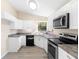 Modern kitchen features white cabinets, stainless steel appliances, and durable countertops at 1550 Maxwell Ln, Deltona, FL 32738