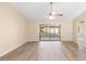 Open living room with wood-look floors and sliding doors to an enclosed lanai at 1550 Maxwell Ln, Deltona, FL 32738