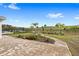 Paver patio with garden and views of golf course beyond black metal fence at 16124 Volterra Pt, Montverde, FL 34756