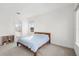Well-lit bedroom featuring a simple wooden bed frame and views through three windows at 16124 Volterra Pt, Montverde, FL 34756