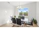 Modern dining room with glass table, comfortable chairs, and a large window with view of the outdoors at 16124 Volterra Pt, Montverde, FL 34756