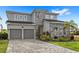 Two-story home with two-car garage, stone accents, and well-manicured lawn and landscaping at 16124 Volterra Pt, Montverde, FL 34756