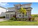 Two-story home features stone accents, manicured lawn and tropical landscaping at 16124 Volterra Pt, Montverde, FL 34756