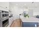 Bright kitchen showcasing white cabinetry, a center island, stainless steel appliances, and modern finishes at 16124 Volterra Pt, Montverde, FL 34756
