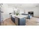 Open concept kitchen featuring a large island, stainless appliances, and seamless flow to the living room at 16124 Volterra Pt, Montverde, FL 34756