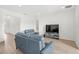 Bright living room with light hardwood floors, features modern seating and a media center at 16124 Volterra Pt, Montverde, FL 34756