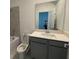 Bathroom featuring a toilet and a vanity with a light countertop, sink, and gray cabinetry at 16436 Parable Way, Winter Garden, FL 34787