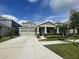 Charming single-Gathering home featuring a two-car garage, welcoming front porch, and beautifully landscaped front yard at 16436 Parable Way, Winter Garden, FL 34787