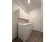 This laundry room has wood-look floors, shelving, and a new washer and dryer at 16436 Parable Way, Winter Garden, FL 34787