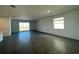 Open-concept living room with sliding glass doors to the patio and dark wood-look tile flooring at 16436 Parable Way, Winter Garden, FL 34787