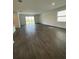 Open-concept living room with sliding glass doors to the patio and dark wood-look tile flooring at 16436 Parable Way, Winter Garden, FL 34787