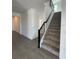 A staircase featuring carpeted steps, a black iron banister, and light gray ceramic tile flooring at 16436 Parable Way, Winter Garden, FL 34787