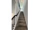 Carpeted staircase featuring a dark railing ascends to the upper level of the home at 16436 Parable Way, Winter Garden, FL 34787