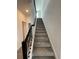 Carpeted staircase featuring a dark railing ascends to the upper level of the home at 16436 Parable Way, Winter Garden, FL 34787