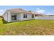 Backyard features a well-maintained lawn, a white vinyl fence, and a covered patio at 1693 Barberry Dr, Kissimmee, FL 34744