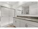 Bright bathroom features a double granite vanity, a large mirror and a glass-enclosed shower at 1693 Barberry Dr, Kissimmee, FL 34744