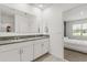 Bright bathroom boasts a double granite vanity, a large mirror and an entrance to the bedroom at 1693 Barberry Dr, Kissimmee, FL 34744