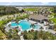 Beautiful community pool area with palm trees, lounge chairs, and a spacious pool house, perfect for socializing at 1693 Barberry Dr, Kissimmee, FL 34744
