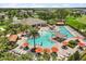 Expansive community pool area with seating, umbrellas, and landscaping. Great view of community amenities at 1693 Barberry Dr, Kissimmee, FL 34744