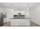 Kitchen island with granite countertops, stainless steel appliances, white cabinetry and modern lighting at 1693 Barberry Dr, Kissimmee, FL 34744
