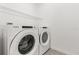 Laundry room features a Whirlpool washer and dryer with a wire shelf for storage at 1693 Barberry Dr, Kissimmee, FL 34744