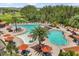 Aerial view of community pool area featuring sun deck with lounge chairs and shaded tables at 1693 Barberry Dr, Kissimmee, FL 34744