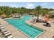Community pool featuring a lap pool, sun deck, and poolside seating under umbrellas at 1693 Barberry Dr, Kissimmee, FL 34744