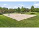 Outdoor sand volleyball court, set in grassy, well-maintained common area with shade trees in the background at 1693 Barberry Dr, Kissimmee, FL 34744