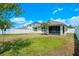 Spacious backyard featuring a well-maintained lawn, privacy fence, and a view of the home at 1836 Partin Terrace Rd, Kissimmee, FL 34744