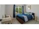 Comfortable bedroom with a plush blue bed, desk, and bright natural light at 1836 Partin Terrace Rd, Kissimmee, FL 34744