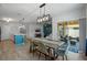 Open-concept dining area with a modern light fixture flowing into a cozy living space and outdoor patio at 1836 Partin Terrace Rd, Kissimmee, FL 34744