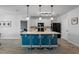 Kitchen island featuring a blue base, modern lighting, and barstool seating at 1836 Partin Terrace Rd, Kissimmee, FL 34744