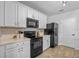 Modern kitchen with white cabinets, black appliances, and stylish backsplash at 1836 Partin Terrace Rd, Kissimmee, FL 34744