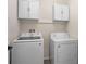 Functional laundry room equipped with white washer, dryer, and cabinets at 1836 Partin Terrace Rd, Kissimmee, FL 34744
