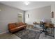 Cozy living room featuring a brown futon, patterned rug, and a workstation with desk and chair at 1836 Partin Terrace Rd, Kissimmee, FL 34744