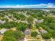 Wide aerial view of a neighborhood with mature trees, houses, and a lake in the distance at 1913 S Summerlin Ave, Sanford, FL 32771