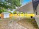 Wide angle shot of the backyard featuring mature landscaping, a storage shed, a yellow fence, and covered patio at 1913 S Summerlin Ave, Sanford, FL 32771