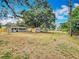 Backyard showing ample space, several storage sheds, mature trees, and yellow fence enclosing the property at 1913 S Summerlin Ave, Sanford, FL 32771