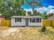Single story white home, gray door, wood fence and simple landscaping at 1913 S Summerlin Ave, Sanford, FL 32771