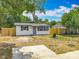 White single story home featuring mature trees, shed, and partial wood fencing at 1913 S Summerlin Ave, Sanford, FL 32771