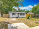 Shot of cozy single-story home and yard featuring mature trees, shed, and partial wood fencing at 1913 S Summerlin Ave, Sanford, FL 32771