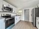 This updated kitchen includes stainless steel appliances, granite countertops, and modern white cabinetry at 1913 S Summerlin Ave, Sanford, FL 32771