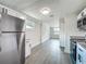 Open kitchen showcasing stainless steel fridge, granite counters, white cabinets, and views into living room at 1913 S Summerlin Ave, Sanford, FL 32771