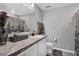 This bathroom features a marble countertop, a large mirror, and a decorative shower curtain at 208 Summerlin Ln, Haines City, FL 33844